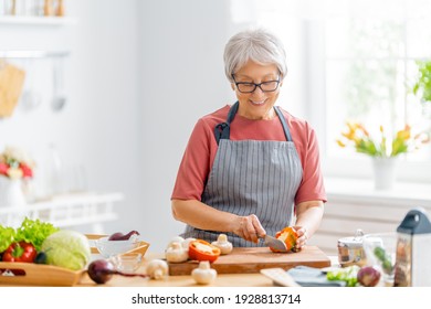 Healthy food at home. Happy woman is preparing the vegetables and fruit in the kitchen.