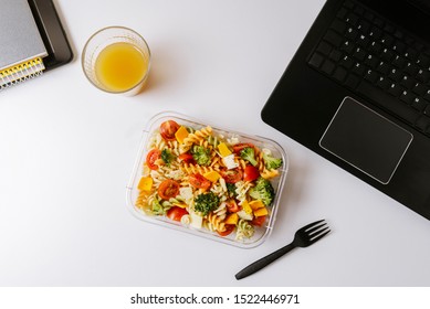 Healthy Food In Lunch Box, On Working Table With Laptop .Ensalada De Pasta Brocoli Con Queso Y Verduras. Eating At Workplace. Home Food For Office Concept 