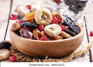 Healthy food: mix from dried fruits in bowl, old wooden background, selective focus