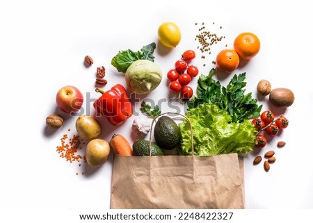 Healthy food. Organic vegetables, vegan vegetarian raw food ingredients in paper bag isolated on white background. Delivery or grocery supermarket and clean vegan eating concept.