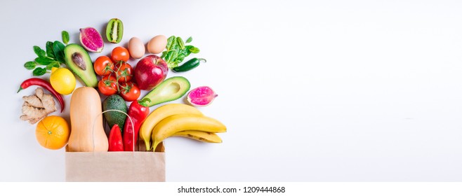 Healthy food in paper bag fruits and vegetables on white. Concept healthy food background. Vegetarian food. Shopping food supermarket. Long web format