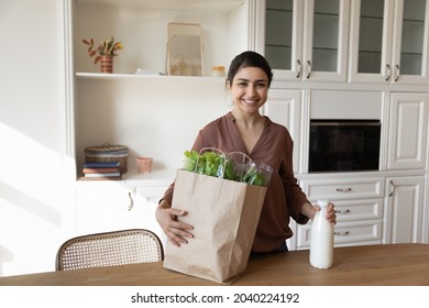 Healthy Food. Portrait Of Young Indian Woman Online Grocery Shop Client Stand At Kitchen Hold Eco Bag With Farmer Product Delivery. Housewife Look At Camera After Successful Shopping At Supermarket