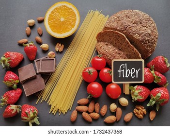 Healthy Food Rich In Fiber. Fiber High Food. Natural Sources Of Fiber: Almond, Strawberry, Dark Chocolate, Cherry Tomato, Whole Grain Bread, Spaghetti, Orange. Healthy Eating.