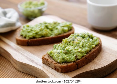 Healthy food. Rye bread with guakomole, avocado pasta on wooden cutting board. Avocado toast for breakfast isolated. - Powered by Shutterstock