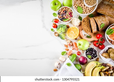 Healthy food. Selection of good carbohydrate sources, high fiber rich food. Low glycemic index diet. Fresh vegetables, fruits, cereals, legumes, nuts, greens. White marble background copy space - Shutterstock ID 1304795521