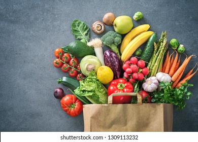 Healthy food selection. Shopping bag full of fresh vegetables and fruits. Flat lay food on table