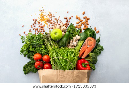 Healthy food shopping or delivery concept, top down view on a variety of fresh produce in a paper bag 