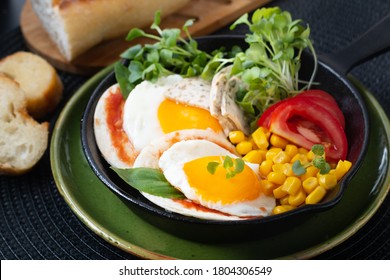 Healthy Food Super Breakfast Concept  Fried Eggs And Micro-green Salad With Corn And Tomato In Skillet Iron Pan With Copy Space