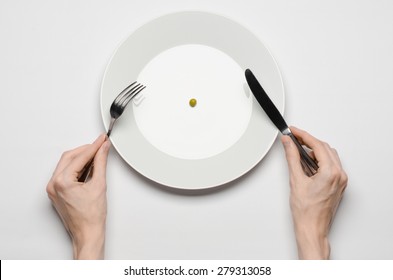 Healthy Food Theme: Hands Holding Knife And Fork On A Plate With Green Peas On A White Table Top View