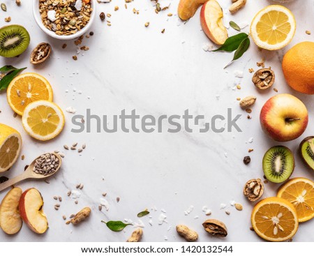 Healthy food vegan breakfast nutrition concept, fresh summer fruits nuts granola seeds on white background, organic super food on table, detox diet for health care, top close up view, copy space