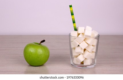 Healthy Food Versus Unhealthy Sugary High-calorie Drinks. Sugar Cubes In A Glass With A Straw And A Green Apple