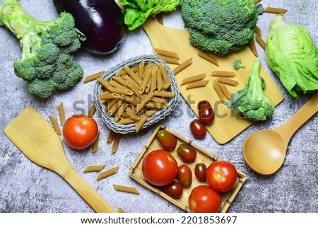 Healthy food, wholemeal macaroni pasta, vegetables and tomatoes, variety of food beneficial for health.