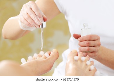 A healthy foot, beautician applies a care product
