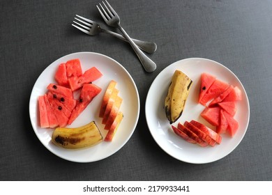 Healthy Fresh Fruit Salad In A White Plate On Black Background. Cut Fruit Plate Of Apple, Banana, And Watermelon Top View. Copy Space.