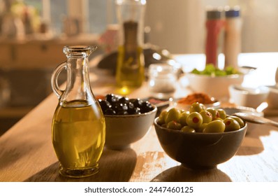 Healthy and fresh green and black olives in separate bowls, with olive oil in a glass bottle. Sunlight hits the kitchen counter. - Powered by Shutterstock