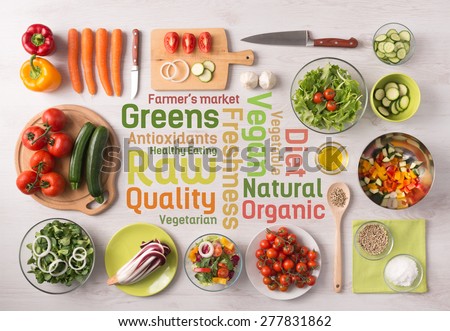 Healthy fresh vegetables salad preparation with kitchen utensils on a table and nutrition text concepts