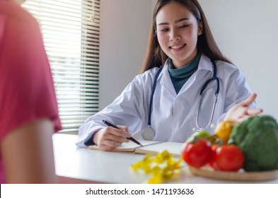 Healthy. Friendly Nutritionist Female Doctor Or Pretty Medical Talking About Diet Plan With Asian Young Patient On Desk In Office Hospital, Nutrition, Food Science, Healthy Food And Dieting Concept