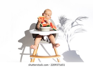 Healthy Fruit Snack. Cute Baby, Child, Kid Emotins. Toddler Boy In Feeding Chair Eats Watermelon, Isolated On White Background. Vegan Healthy Diet, Feeding, Solid Food Concept. Copy Space.