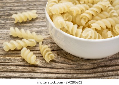 Healthy, Gluten Free Quinoa Pasta (fusilli)  - Small Ceramic Bowls Against Grained Wood