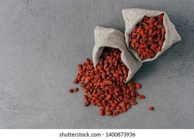 Healthy goji berries spilled out of small sack, isolated over grey background. Agriculture and nutrition concept. Superfood - Powered by Shutterstock