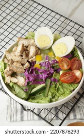 Healthy Green Salad With Chicken Breas, Fusilli Pasta, Tuna Mayo, Tomatoes, With Boiled Egg With Sesame Dressing And Olive Dressing Isolated On White Background