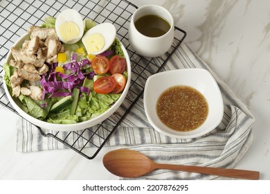 Healthy Green Salad With Chicken Breas, Fusilli Pasta, Tuna Mayo, Tomatoes, With Boiled Egg With Sesame Dressing And Olive Dressing Isolated On White Background