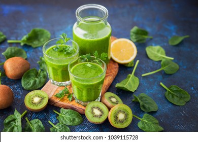 healthy green smoothie with ingredients on blue table - food and drink