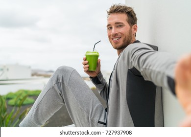 Healthy green smoothie selfie sport fitness man taking self portrait picture at gym drinking vegetable juice after workout in sweatpants and sportswear. - Powered by Shutterstock