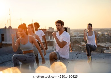 Healthy group of fit multiethnic friends exercising together outdoors. Sport people fun concept. - Powered by Shutterstock