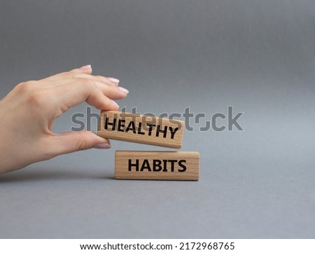 Healthy habits symbol. Concept word Healthy habits on wooden blocks. Beautiful grey background. Businessman hand. Business and Healthy habits concept. Copy space