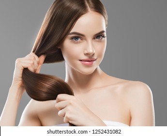 Healthy hair woman with long smooth brunette hair and natural makeup over gray background - Shutterstock ID 1252431082