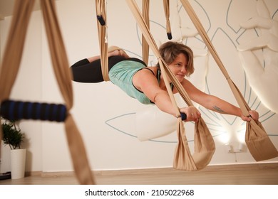 Healthy Happy Mature Woman Doing Superman Pose On Aerial Yoga Hammock