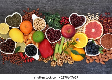 Healthy heart food high in flavonoids, polyphenols, antioxidants, anthocyanins, lycopene, vitamins, proteins, bioflavonoids, minerals, fibre. On rustic wood background.