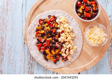 Healthy High Protein Burritos With Eggs, Bell Peppers, Sweet Potato, Black Beans On Whole Wheat Tortillas With Grated Cheese, Top View. Healthy Breakfast On Wooden Table