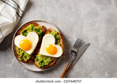 Healthy holidays breakfast with eggs hearts, croissants and cup of coffee on grey background, top view, copy space - Shutterstock ID 2107648757