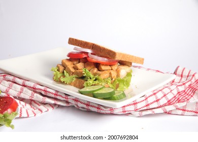 healthy home made chicken tikka sandwich with fresh vegetables on a white plate table top food photography