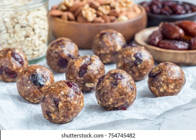 Healthy homemade energy balls with cranberries, nuts, dates and rolled oats on parchment, horizontal - Powered by Shutterstock