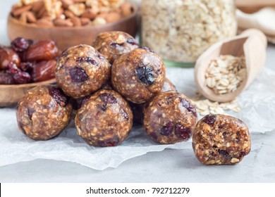 Healthy homemade energy balls with cranberries, nuts, dates and rolled oats on a parchment, horizontal