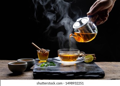 Healthy hot tea with hot steam, honey water and a cup of beautifully placed tea. - Healthy herbal water concept