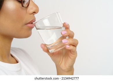 Healthy And Hydrated. Side View Of Young African American Woman Drinking Pure Mineral Water While Standing Isolated Over Grey Studio Background. Maintenance Of Fluid Balance And Hydration Concept