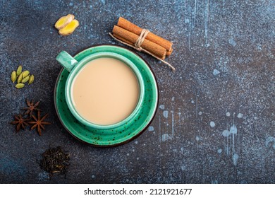 Healthy Indian Beverage Masala Chai - Tea Hot Drink With Milk And Spices In Rustic Green Teacup With Ingredients For Making Masala Chai From Above On Concrete Blue Background Copy Space