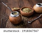 Healthy infused drink, classic Yerba Mate tea in a gourd with mobilla on wooden background