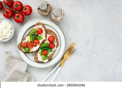 Healthy italian bruschetta with ricotta cheese, romaine lettuce and roasted cherry tomatoes. Table top view, copy space - Powered by Shutterstock