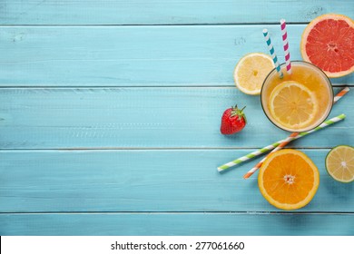 Healthy juice and fresh fruits on wood background