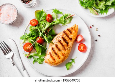 Healthy keto, ketogenic lunch with grilled chicken meat and organic veggies and greens. Roasted chicken breast, fillet and fresh vegetable salad, top view, copy space.
