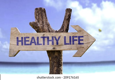Healthy Life wooden sign with a beach on background 