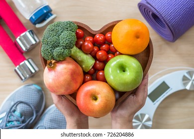 Healthy lifestyle concept, eating clean food good health dietary in heart dish with sporty aerobic body exercise workout training class gym equipment, weight scale and sports shoes in fitness center - Shutterstock ID 726204886