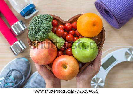 Healthy lifestyle concept, eating clean food good health dietary in heart dish with sporty aerobic body exercise workout training class gym equipment, weight scale and sports shoes in fitness center