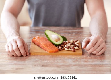 healthy lifestyle, diet and people concept - close up of male hands with food rich in protein on cutting board on table - Shutterstock ID 283178141