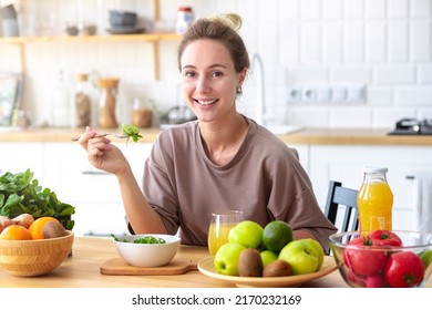 Healthy Lifestyle, Diet, Weight Loss Concept Beautiful Happy Woman Eats Breakfast Looking At The Camera And Smiling Friendly Beautiful Female Eating Fresh Salad While Sitting In Kitchen Vegan Meal 